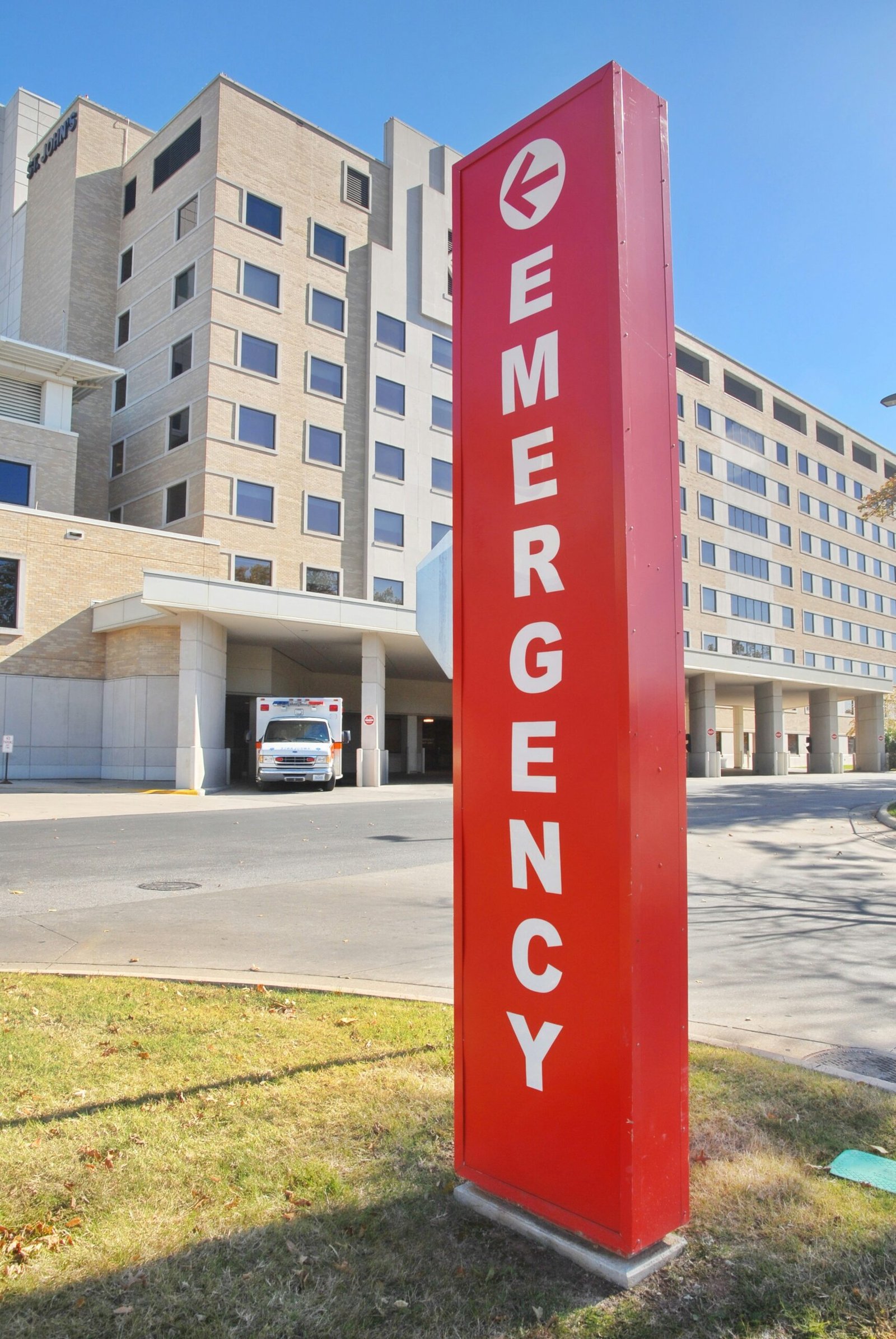 a red emergency sign in front of a large building